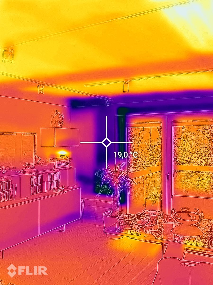 Imagen térmica de una sala de estar con el techo caliente por la calefacción de techo y un punto de medición de 19,0 grados en el muro exterior junto a la puerta de la terraza.